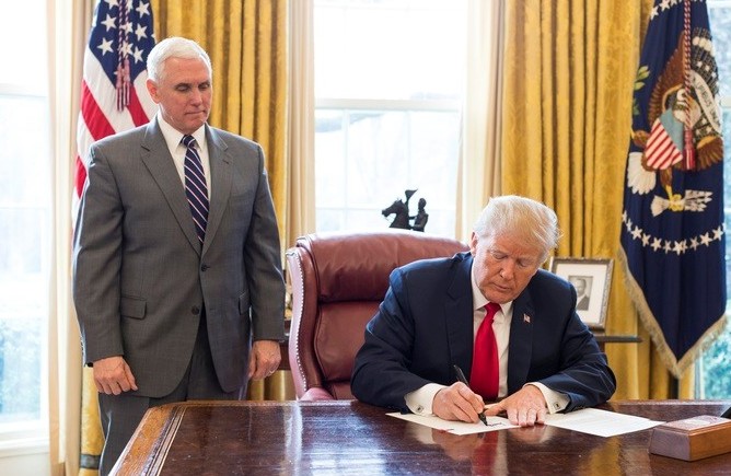 President Donald J. Trump, joined by Vice President Mike Pence, signs an Executive Order, Monday, March 19, 2018, in the Oval Office at the White House, to take additional steps to stop the Maduro regime of Venezuela from attempting to circumvent U.S. sanctions by issuing a digital currency.