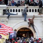 FILE PHOTO: A mob of supporters of U.S. President Donald Trump fight with members of law enforcement at a door they broke open as they storm the U.S. Capitol Building in Washington, U.S., January 6, 2021.