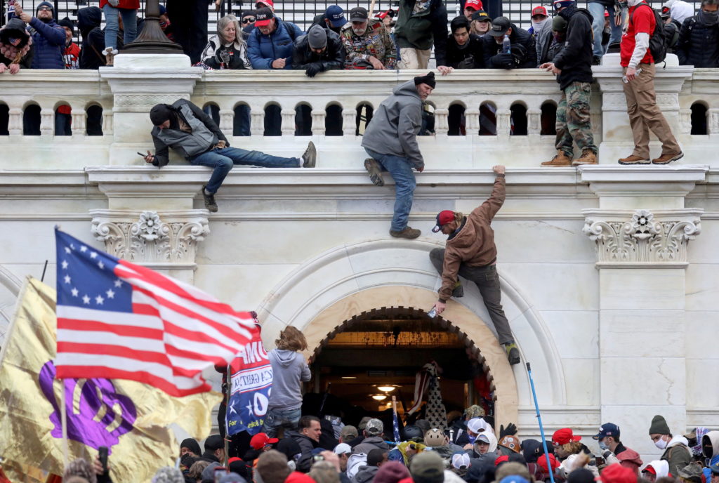 FILE PHOTO: A mob of supporters of U.S. President Donald Trump fight with members of law enforcement at a door they broke open as they storm the U.S. Capitol Building in Washington, U.S., January 6, 2021.
